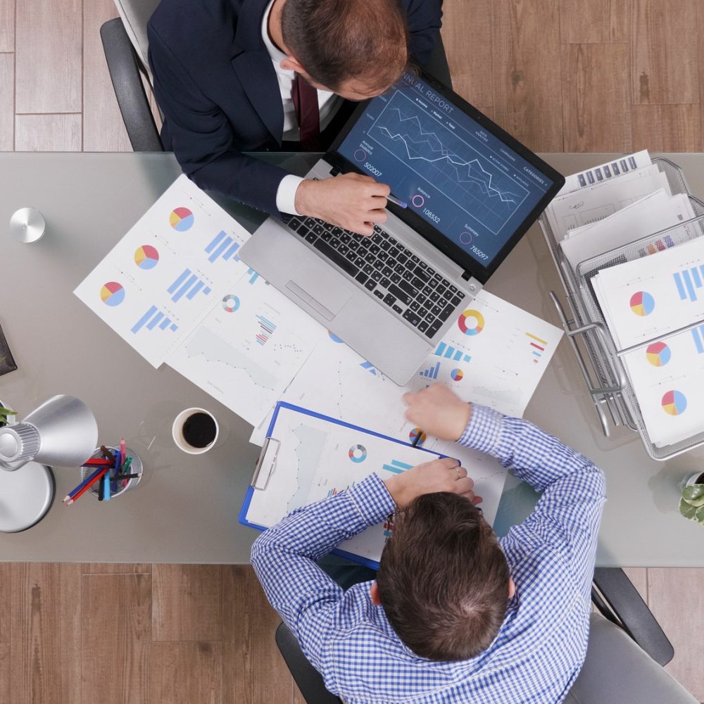 top-view-of-businessmen-analyzing-management-statistics-while-working-at-company-investments-1.jpg
